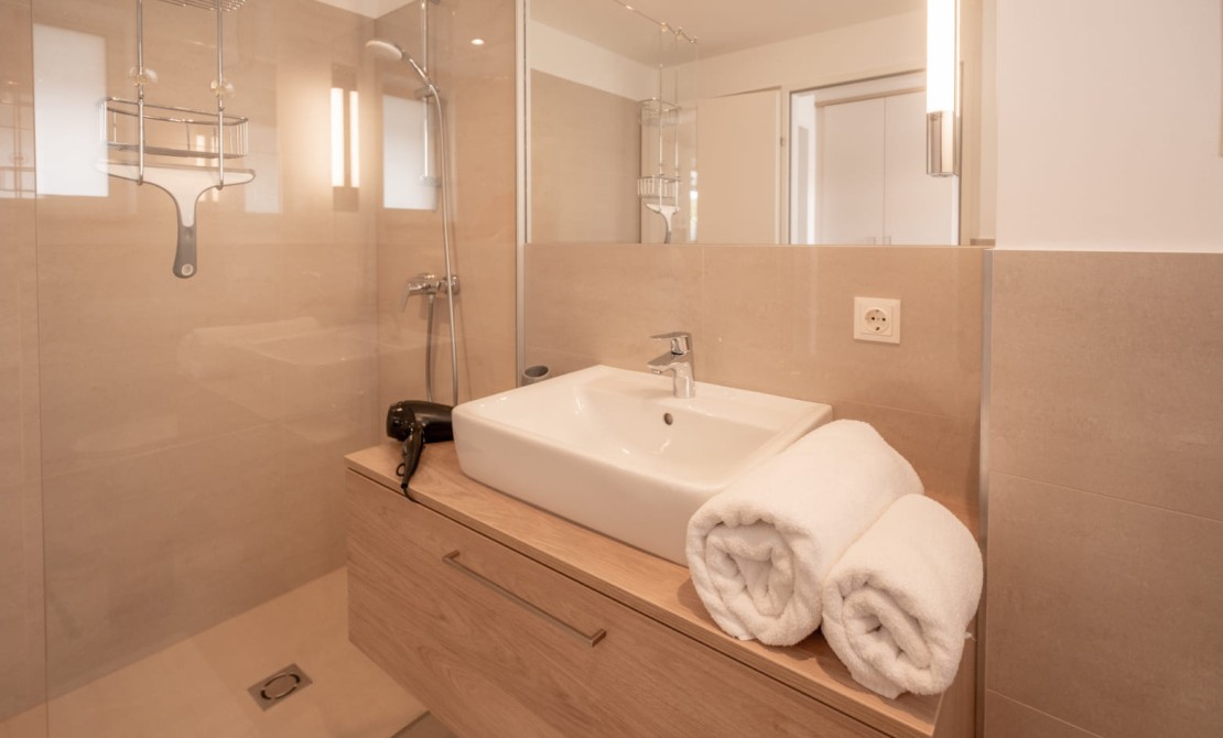Modernes Badezimmer mit ebenerdiger Dusche und hochwertiger Ausstattung