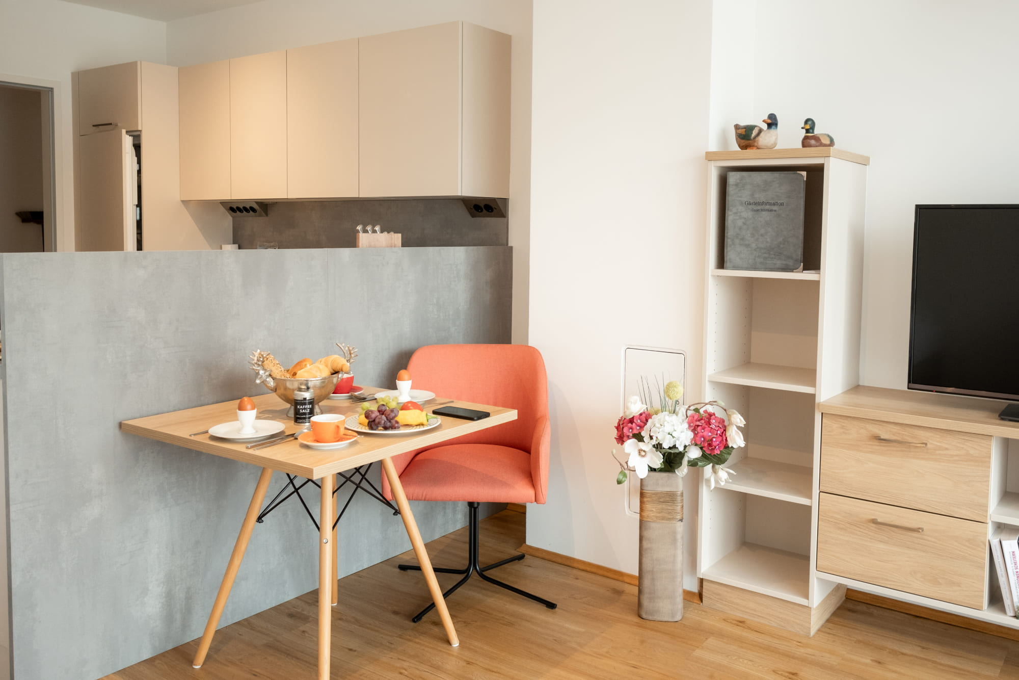 Heller Wohnbereich eines Apartments im Waldviertel mit Küchenzeile und gedecktem Esstisch